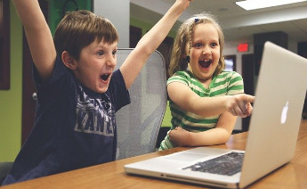 Zwei Kinder sitzen enthusiastisch vor einem Laptop 
Foto: Pixabay/StartupStockPhotos